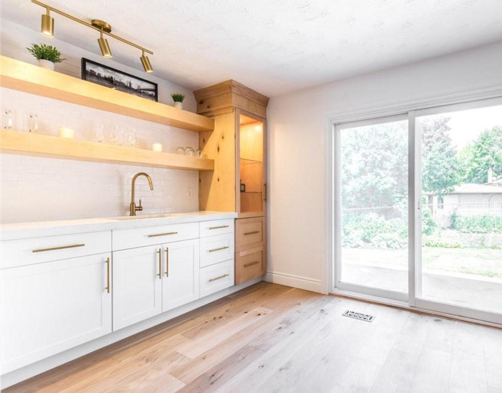 a bar sink in a kitchen with white cabinets