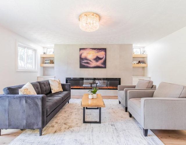 living room with a grey sofa and two beige arm chairs