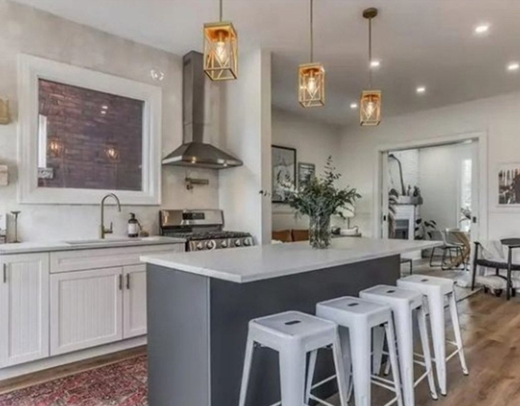 four white bar stools pulled up to a kitchen island