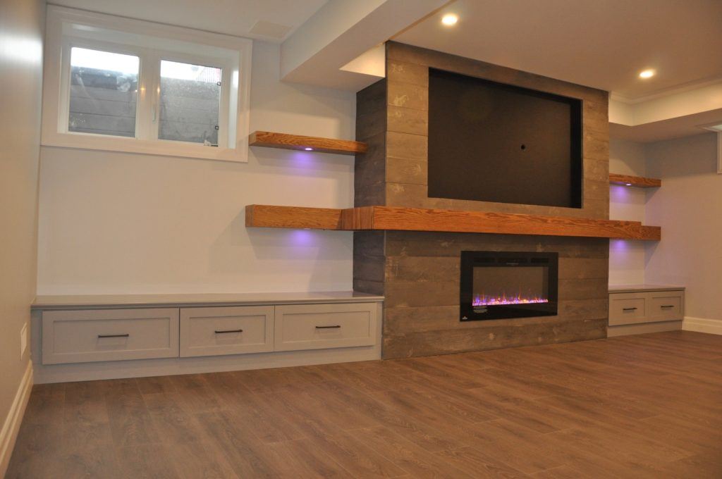 basement with a gas fireplace and wooden mantle