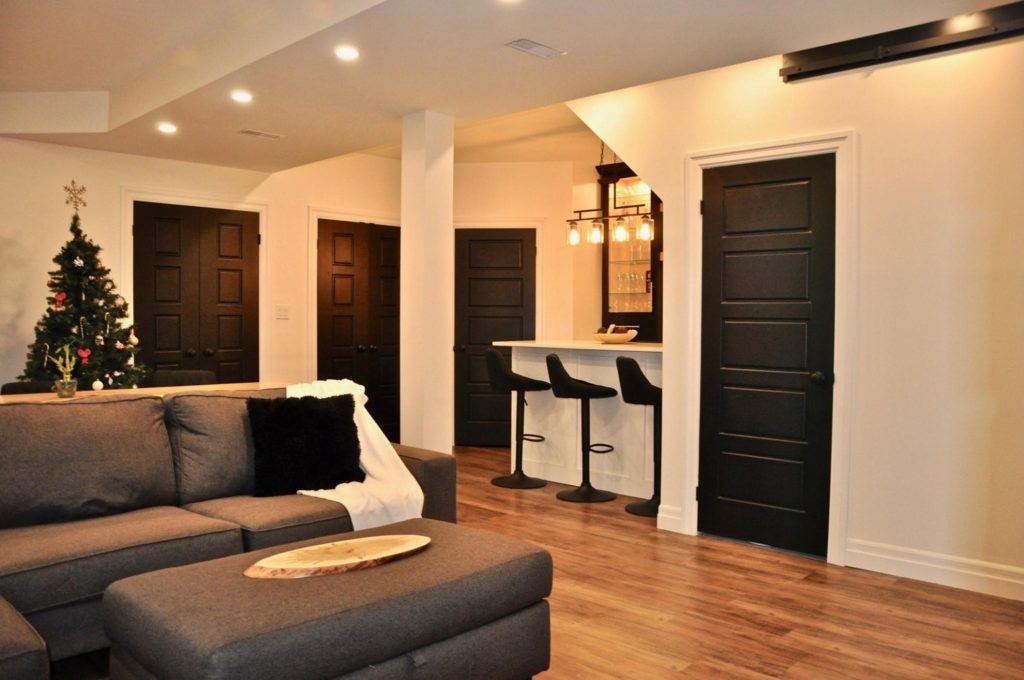 basement living room with a grey sofa and hardwood floors