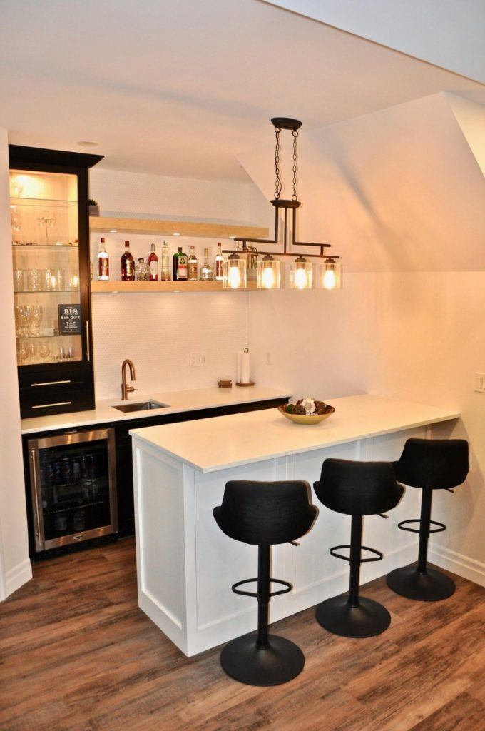 a home bar with three black bar stools