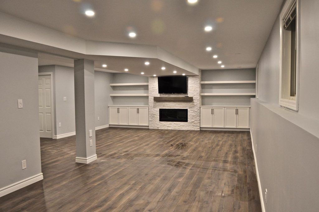 empty remodelled basement with a white gas fireplace