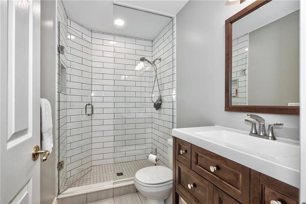 a bathroom vanity with a white tiled glass door shower