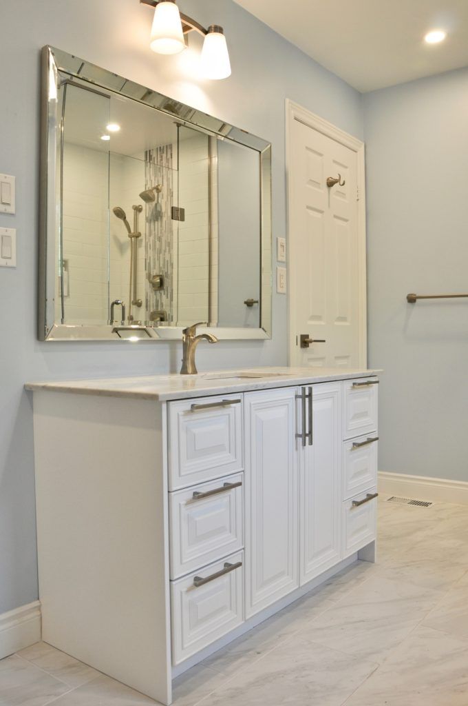 a white bathroom vanity with a white since and brass finishes
