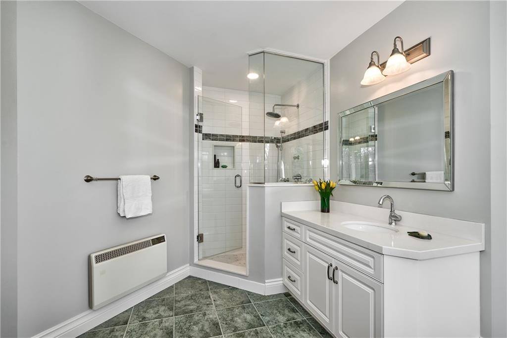 a bathroom vanity with a sink and glass door shower