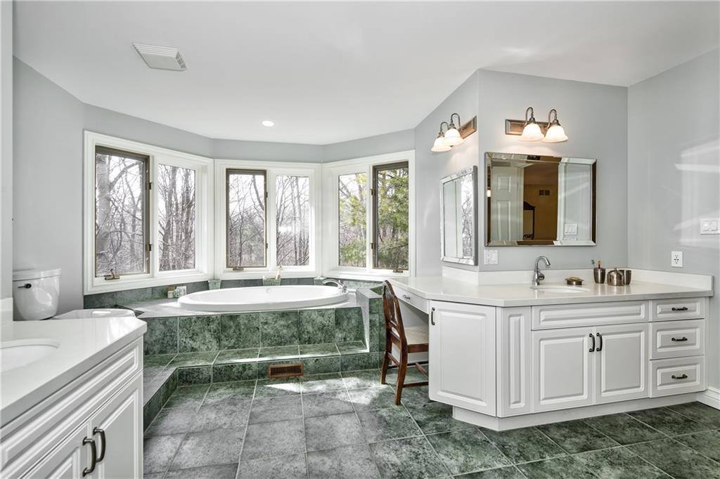 bathroom with green tiled floor and white vanity