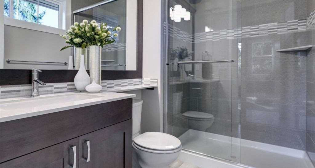 a dark wood bathroom vanity next to a white toilet