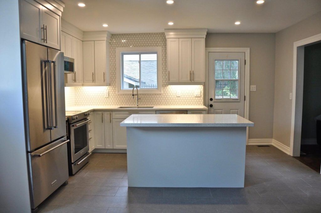 remodelled kitchen with white countertops and grey and white cabinetry