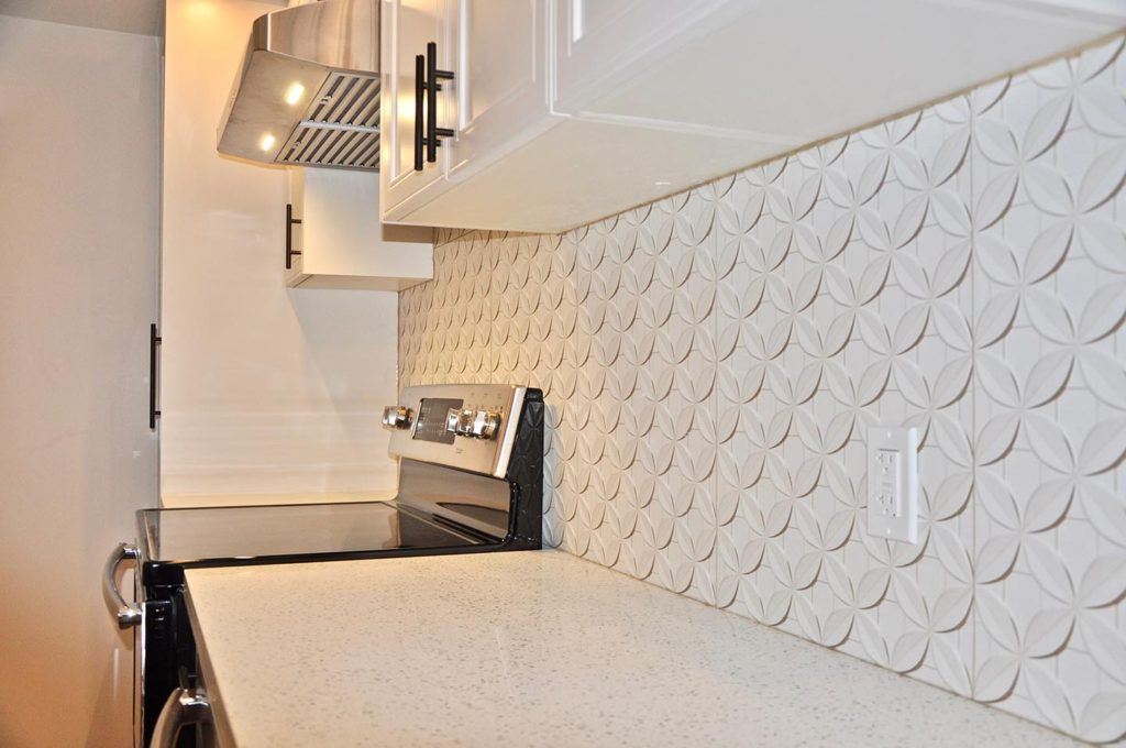 close up photo of a white patterned kitchen backsplash