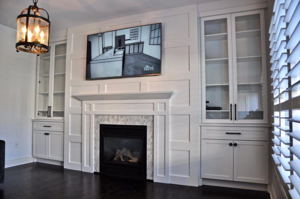 flatscreen television above a fireplace with a mantle