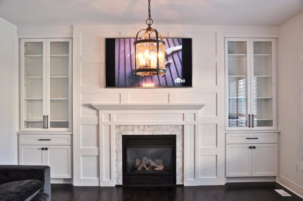 flatscreen television above a fireplace with a mantle